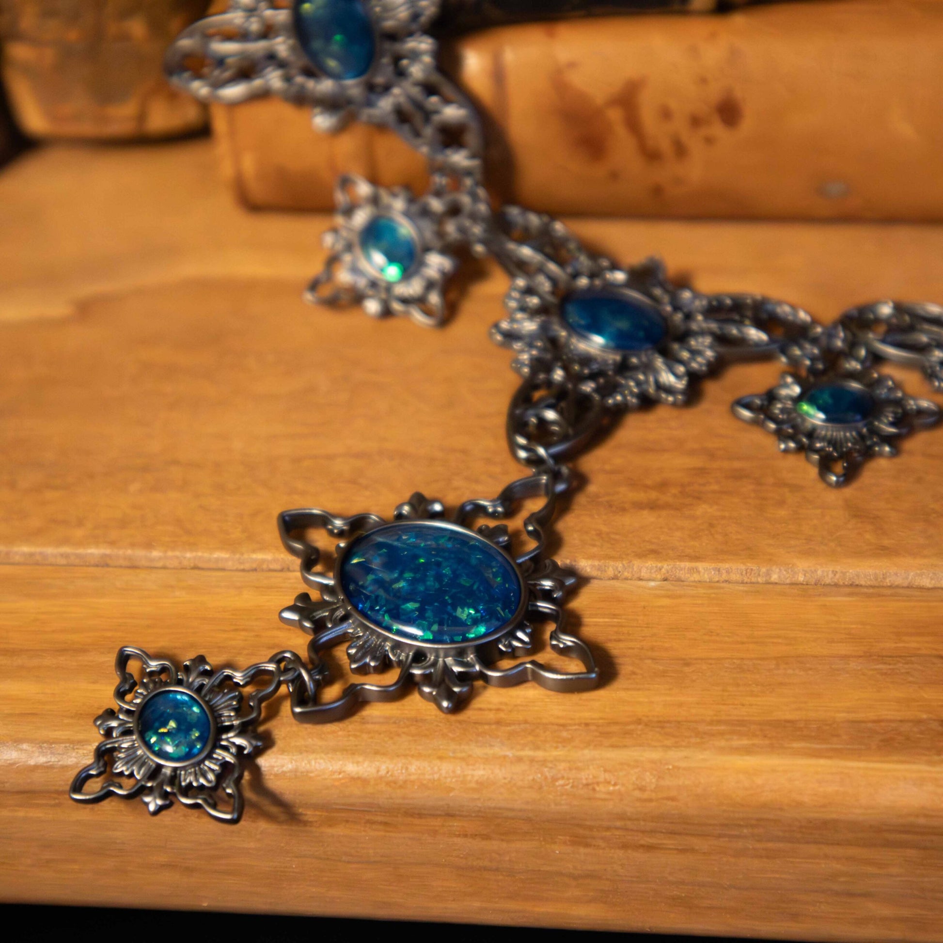 Silver necklace with blue stones on a wooden surface