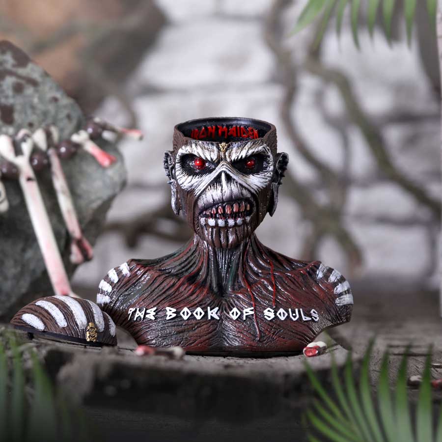 A sculpted bust of the Iron Maiden 'The Book of Souls' mascot, Eddie, featuring dark brown textured skin, white painted stripes, a red eye, and the text 'THE BOOK OF SOULS' on the front on display