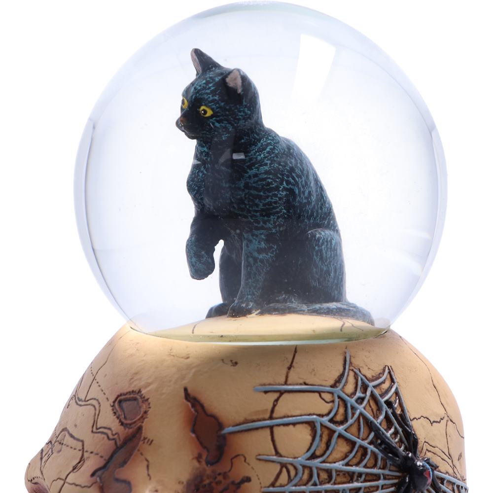 Close-up of the Spirits of Salem Snow Globe showing the black witch's familiar, aged skull and intricate Gothic details