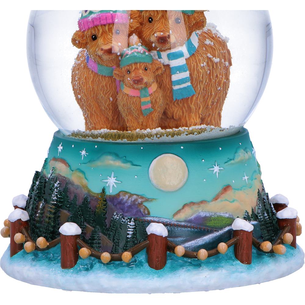 Detailed resin base of the Winter Highland Cow Snow Globe featuring a rustic fence, woodland, mountains, stars and full moon.