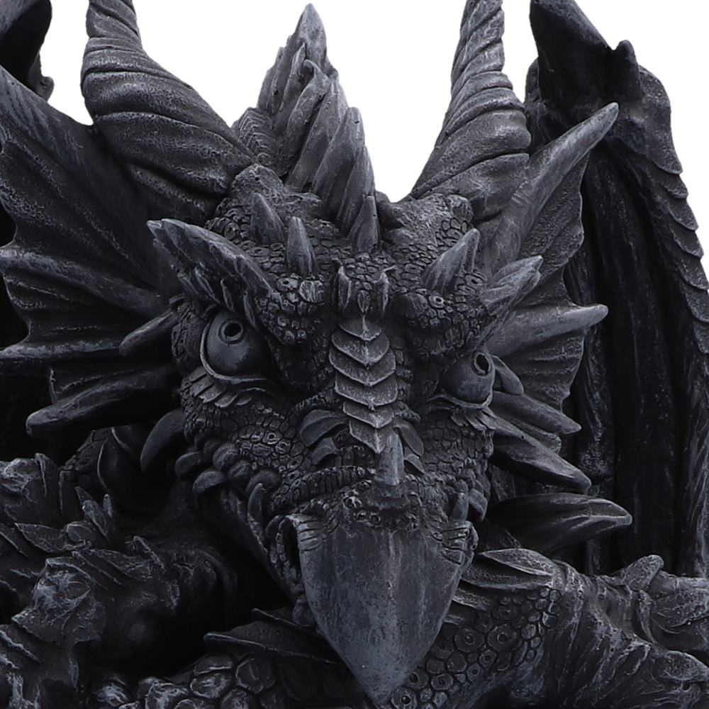 Close-up of a detailed black dragon figurine with textured scales, sharp horns, and a fierce expression