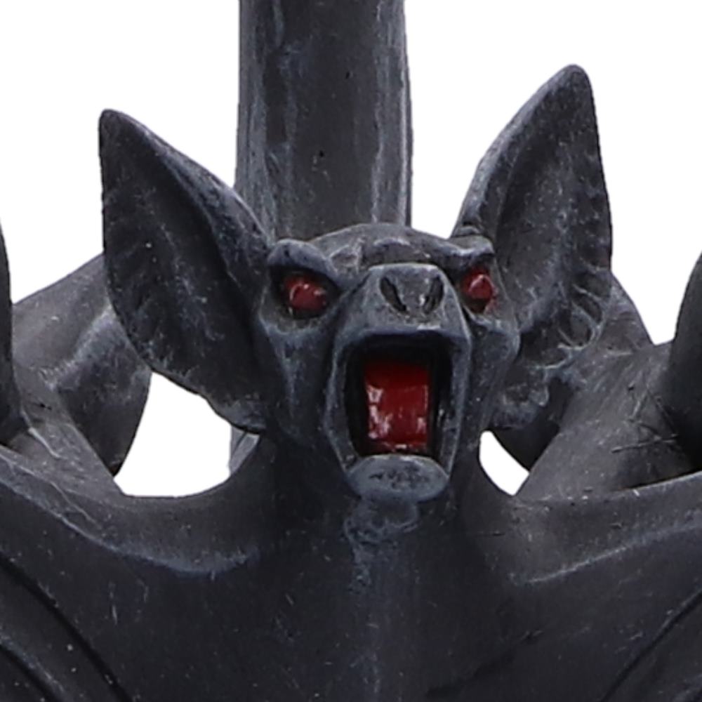 A close-up of a dark gray bat figurine with red eyes and an open mouth showing red tongue and teeth.
