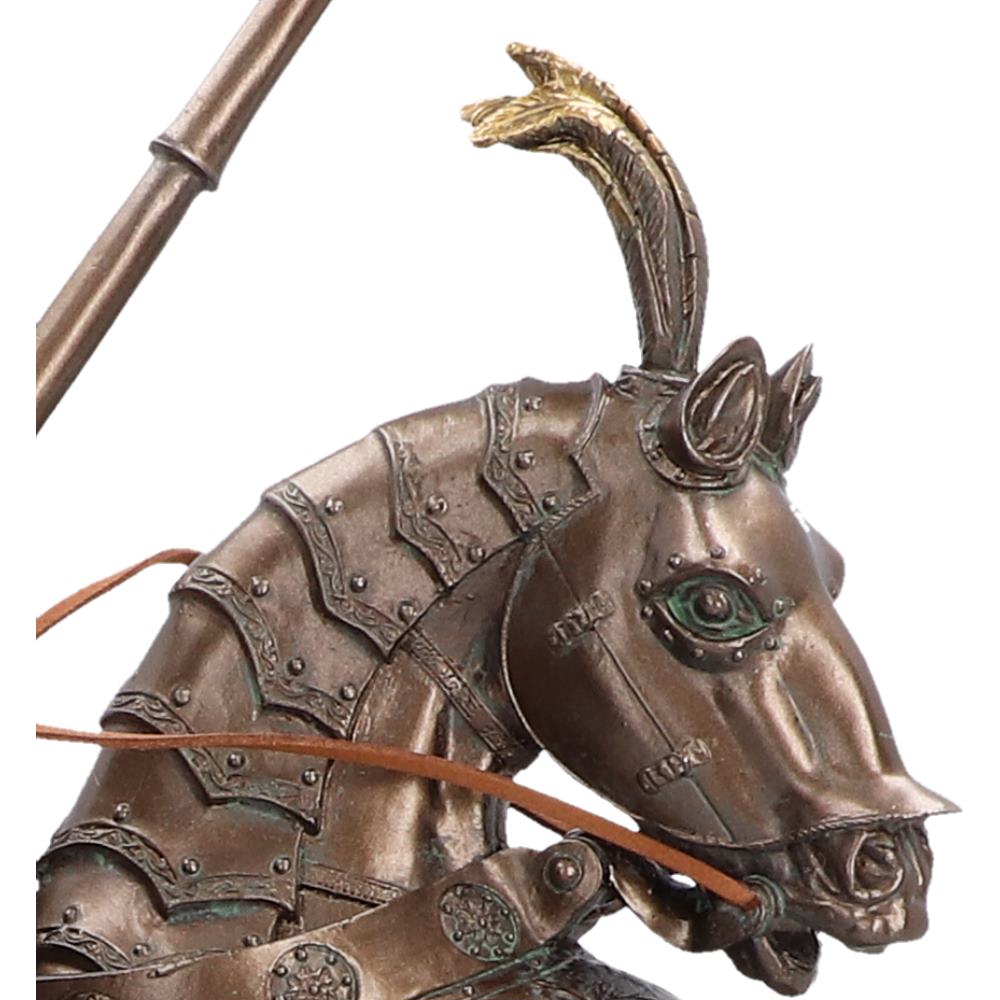 Close-up of a metallic horse figurine wearing detailed armor, with a curved horn and a bronze-colored body.
